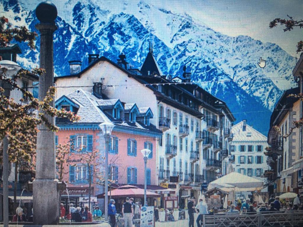 uma rua com edifícios e uma montanha ao fundo em OUTA Chamonix centre em Chamonix-Mont-Blanc