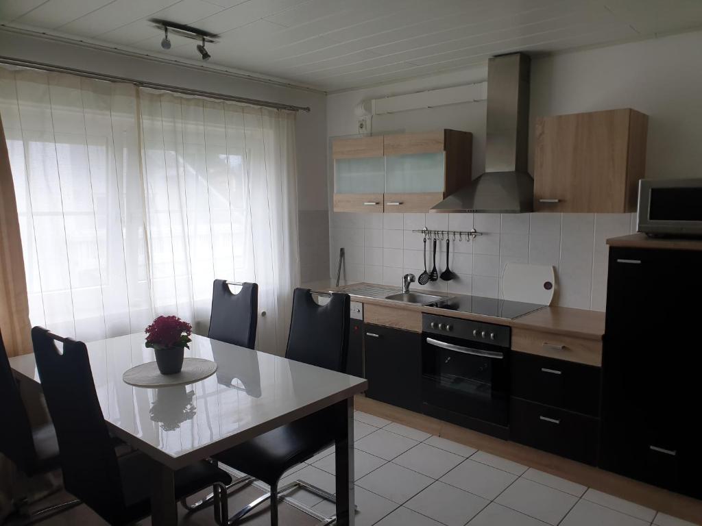 eine Küche mit einem Tisch, einem Tisch und Stühlen in der Unterkunft Lindner Ferienwohnungen und Doppelzimmer in Fichtelberg