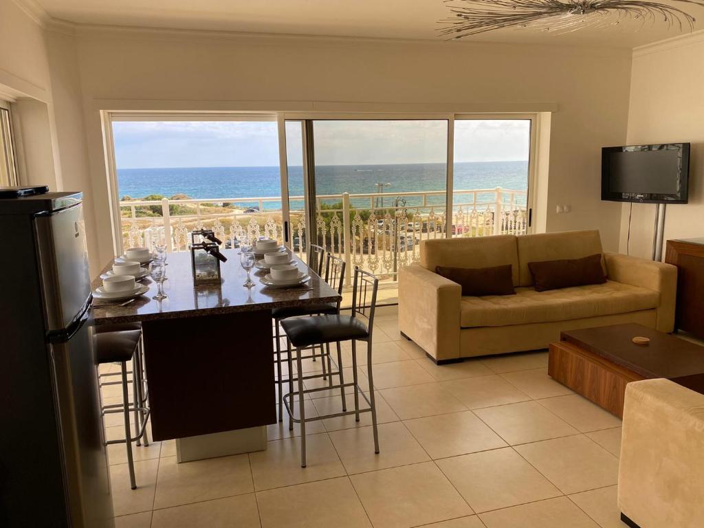 a living room with a table and a view of the ocean at LUNA - Airco - Sea view - First line - Own parking in Armação de Pêra