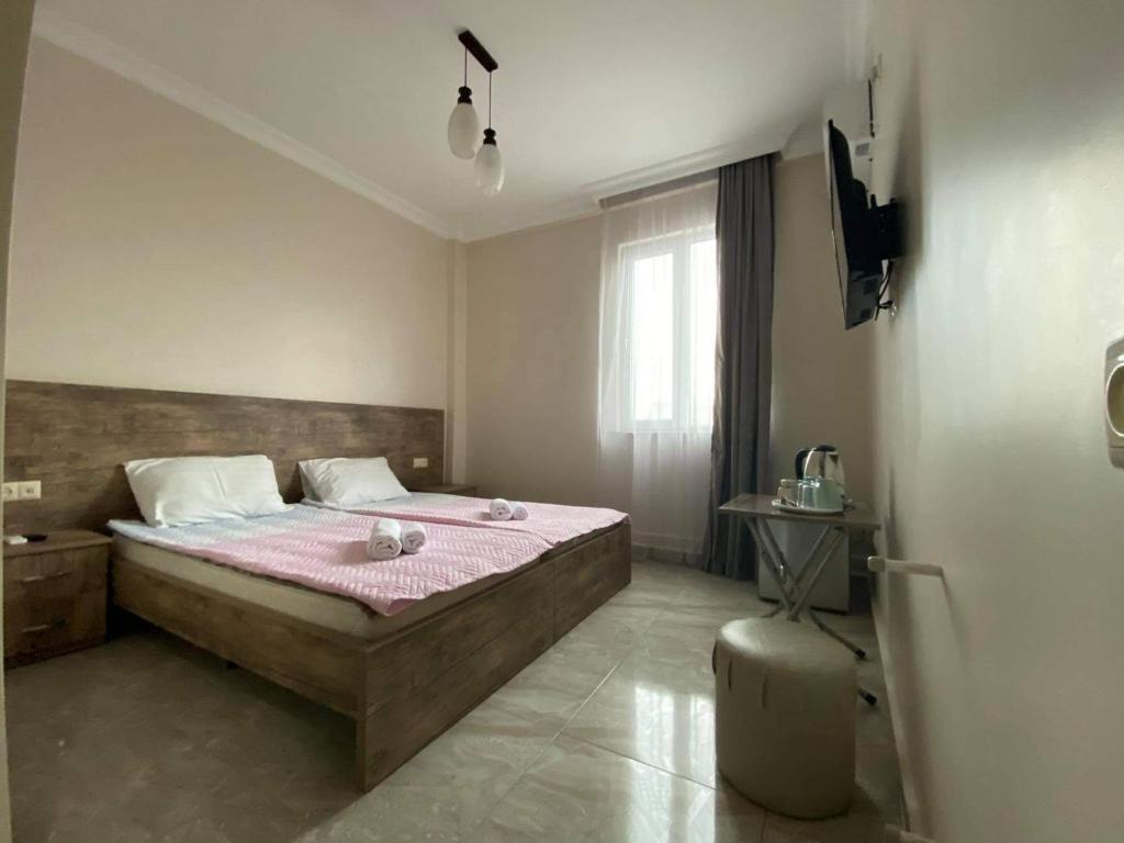 a bedroom with a large bed with a pink blanket at Family Hotel in Batumi