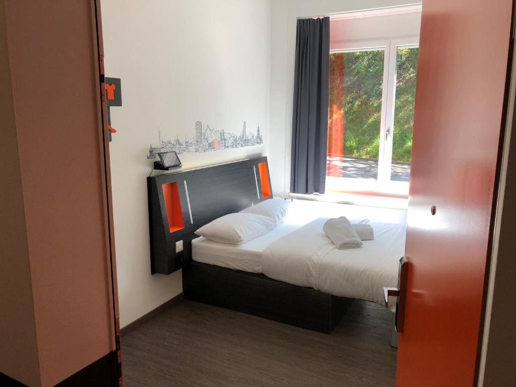 a small bedroom with a bed and a window at easyHotel Zürich West in Zurich