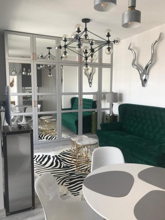 uma sala de estar com um sofá verde e uma mesa em Luxury Wola Apartament em Varsóvia