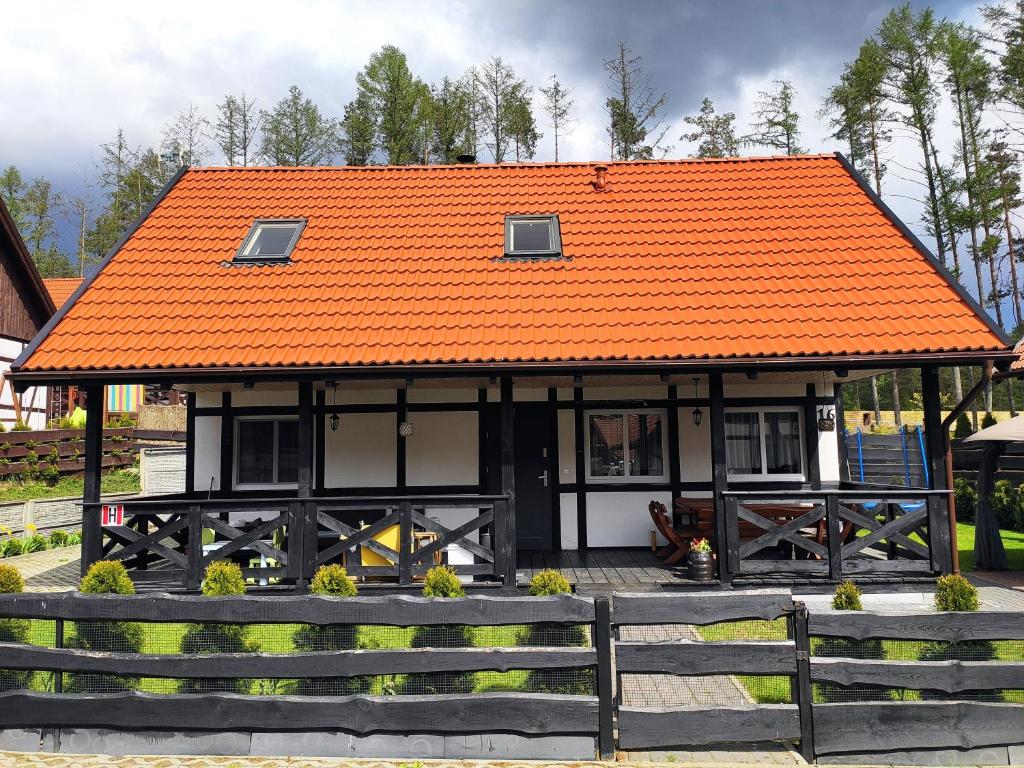 ZałakowoにあるTomaszówka - Domek na Kaszubachの塀付きの建物のオレンジ色の屋根