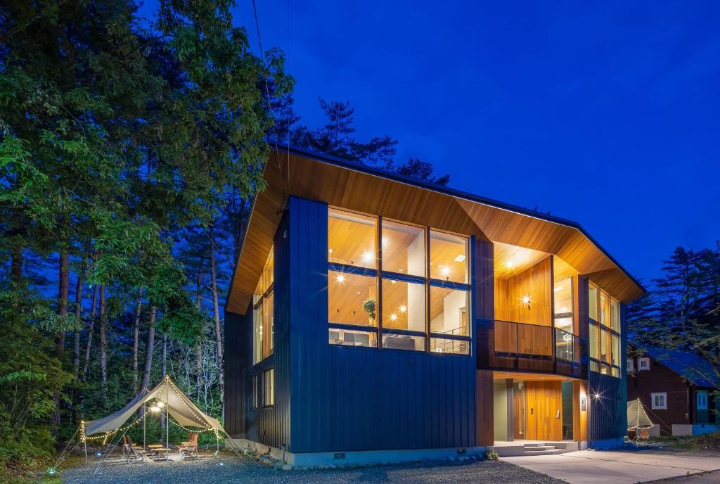 una casa con una fachada azul por la noche en Hakuba Jade Chalet by Jade Group, en Hakuba