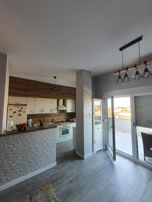 a kitchen with white cabinets and a brick wall at Apartment Sara in Umag