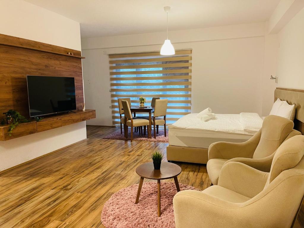 1 dormitorio con 1 cama, mesa y sillas en Fuk-tak apartmani&restoran en Star Dojran