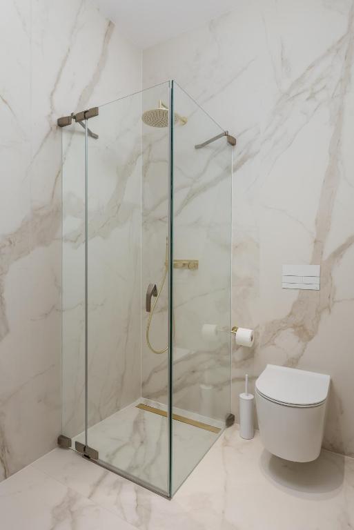 a glass shower in a bathroom with a toilet at Plaza Apartments in Opatija