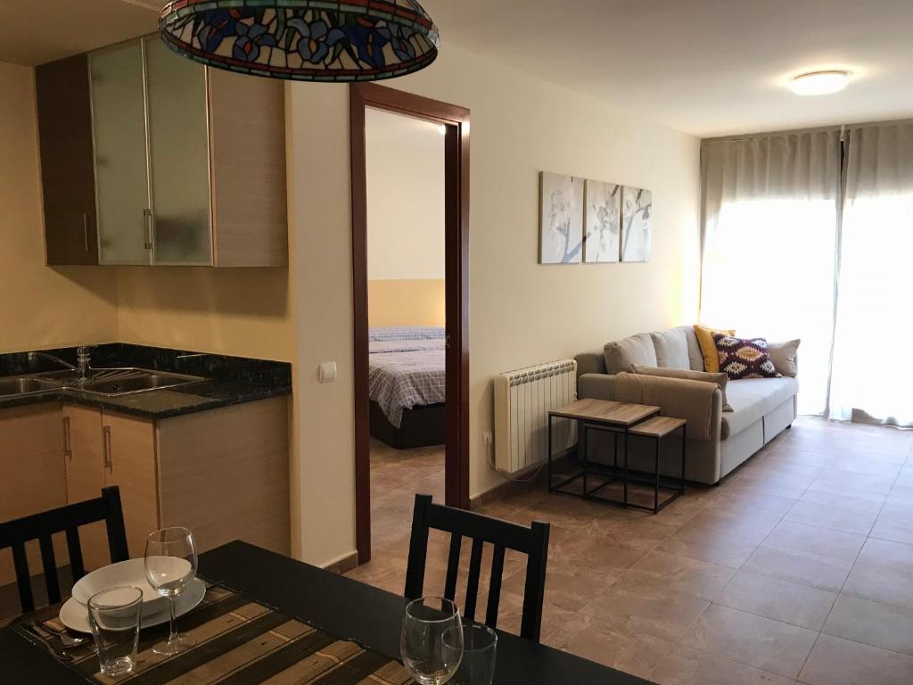 eine Küche und ein Wohnzimmer mit einem Tisch und einem Sofa in der Unterkunft Moixeró in Guardiola de Berga