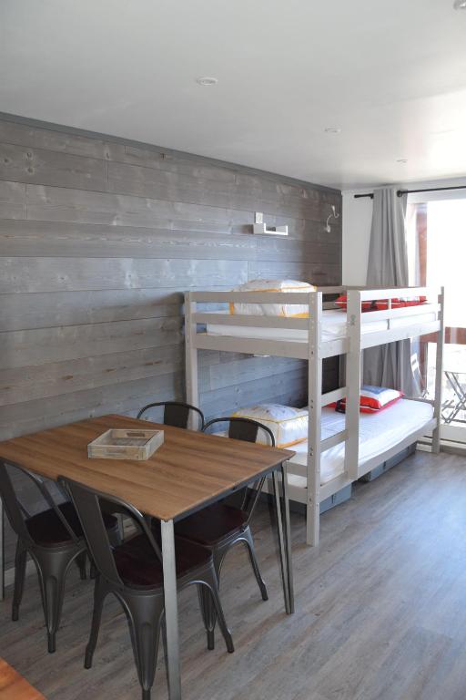 een eetkamer met een tafel en een stapelbed bij Appartement Studio rénové le Corbier 4 personnes 22m2 domaine les Sybelles Classé 2 étoiles label qualité le corbier in Villarembert