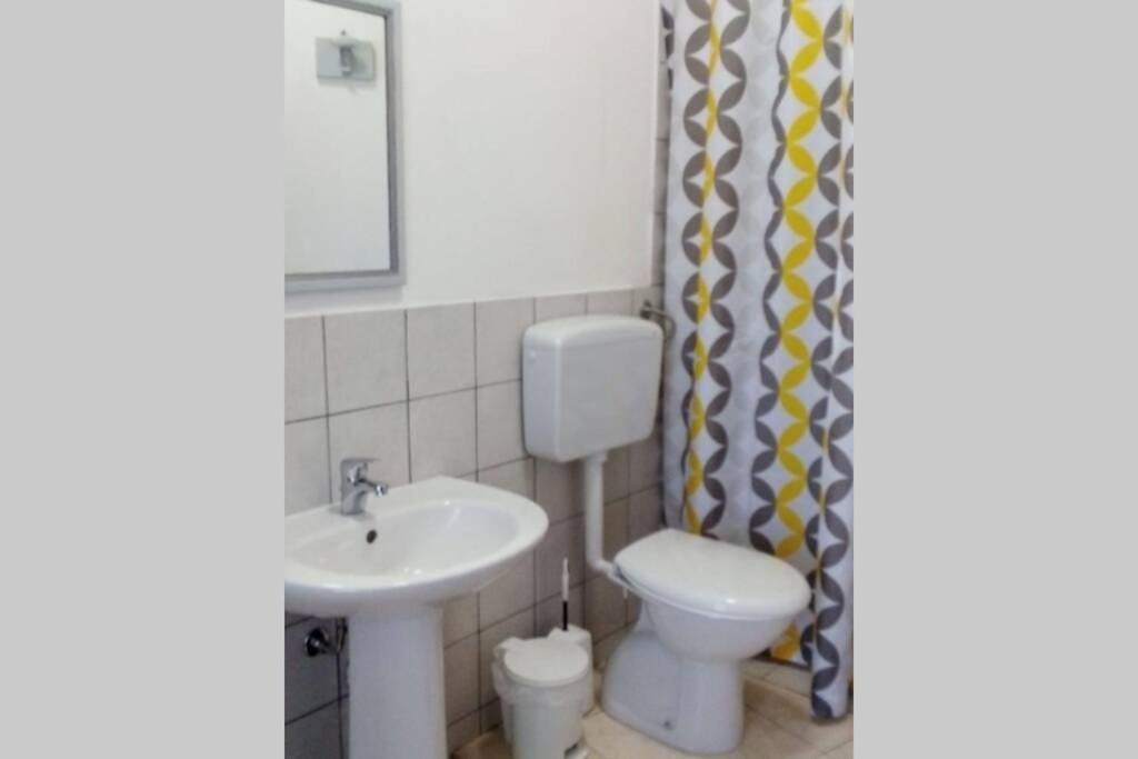 a bathroom with a white toilet and a sink at Il rifugio dello scultore in Niscemi