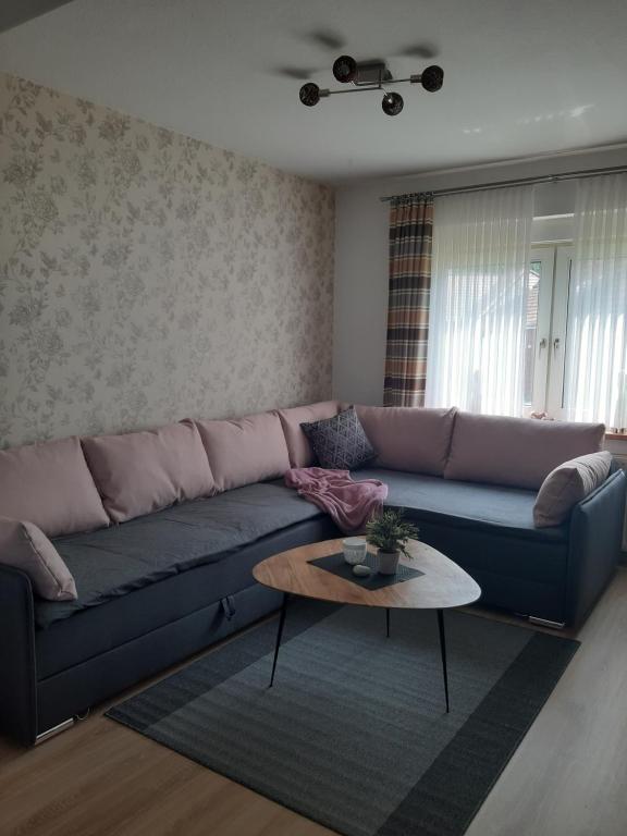 sala de estar con sofá azul y mesa en Ferienwohnung Am Ostfriesland-Wanderweg en Rhauderfehn