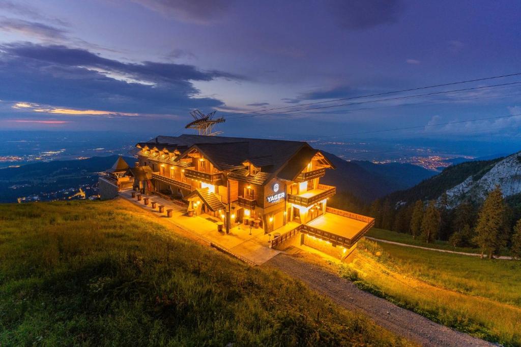 a large house on top of a hill at night at Yager Chalet in Poiana Brasov