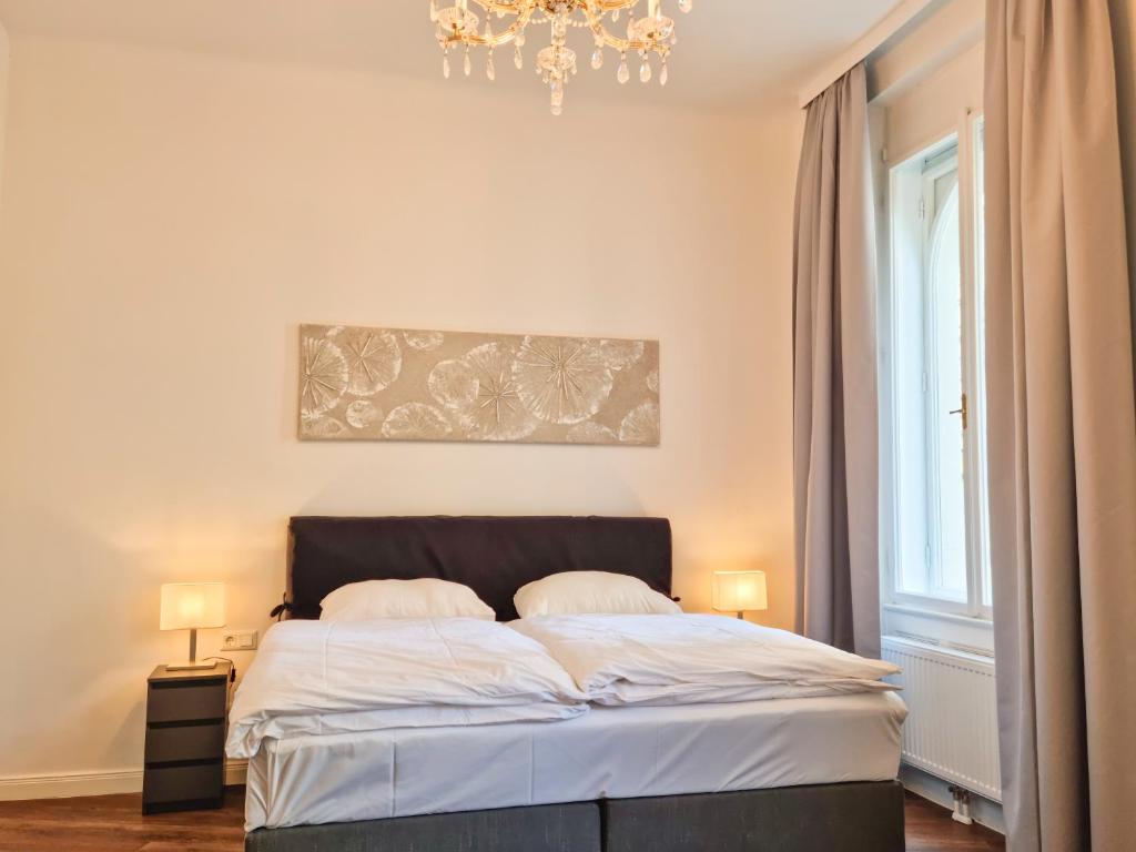 um quarto com uma cama e um lustre em Pension Mozart - Newly Renovated em Viena