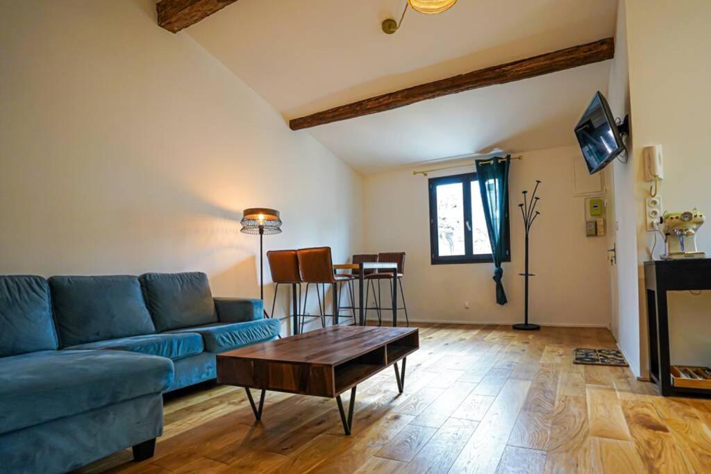 sala de estar con sofá azul y mesa en Le petit Corum - HH en Montpellier