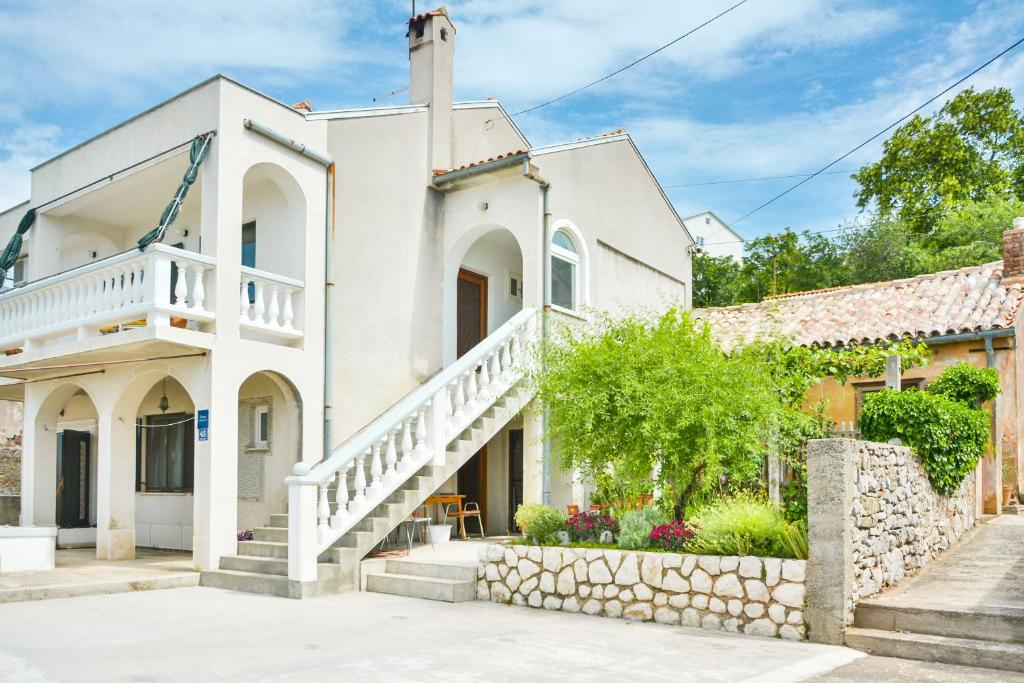 a white house with a staircase in front at Apartman Gabrijela in Senj