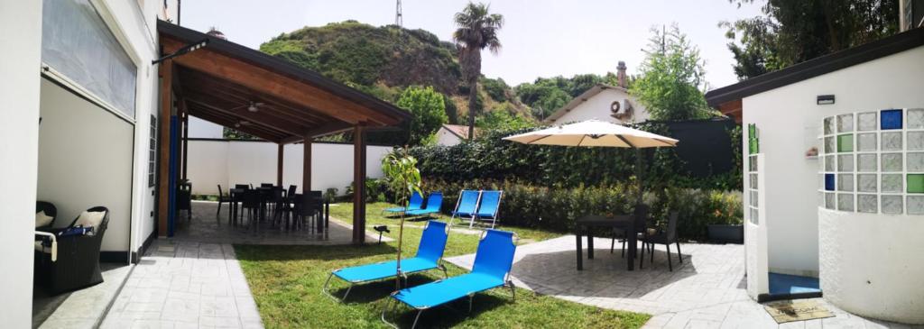 a patio with blue chairs and an umbrella at La Casa di Anna in Palmi