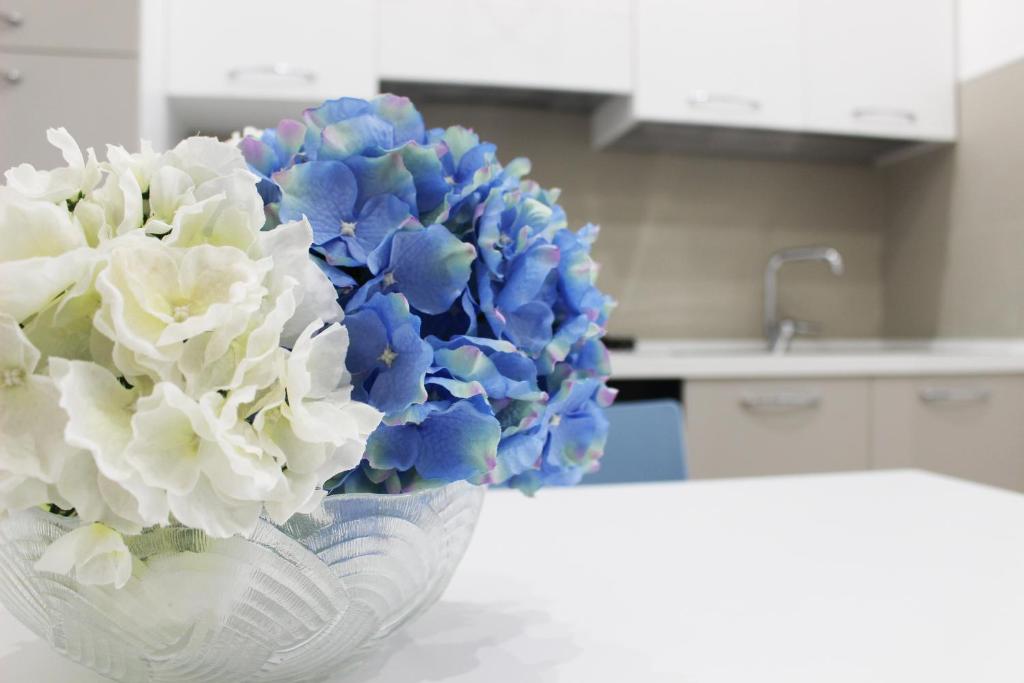 a glass vase with blue and white flowers in a kitchen at Casa Thalassa in Cefalù