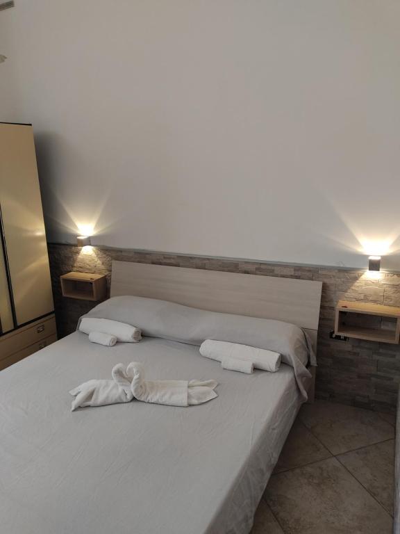 a white bed with two white towels on it at Casa Solemare in Torre Lapillo
