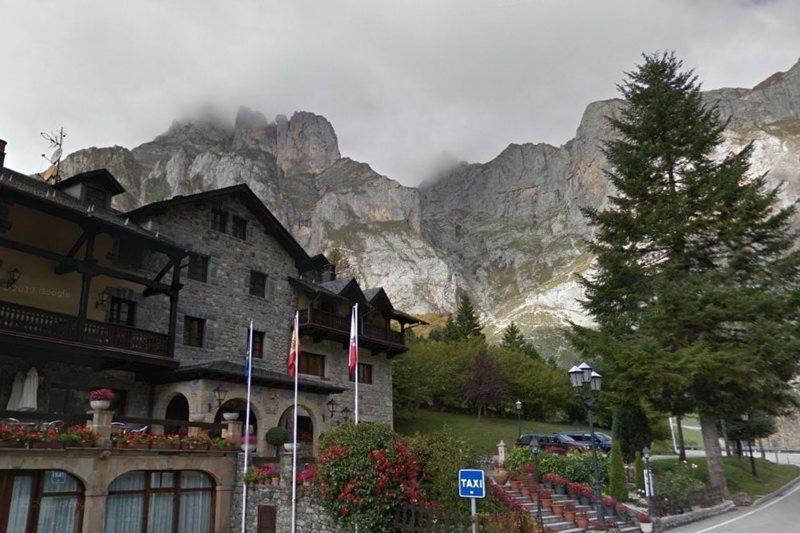 un edificio frente a una montaña con montañas de fondo en Hotel Rebeco, en Fuente Dé