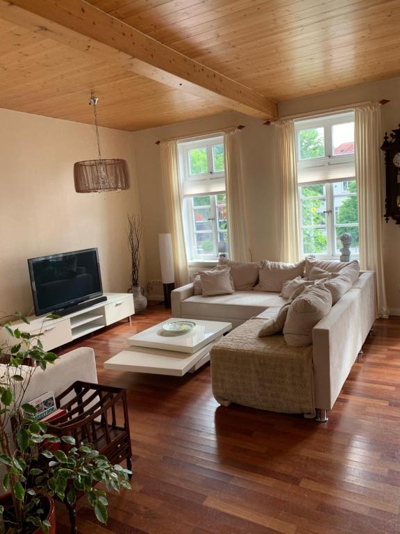 a living room with a couch and a tv at Schloss Blick Bredendiek in Jever