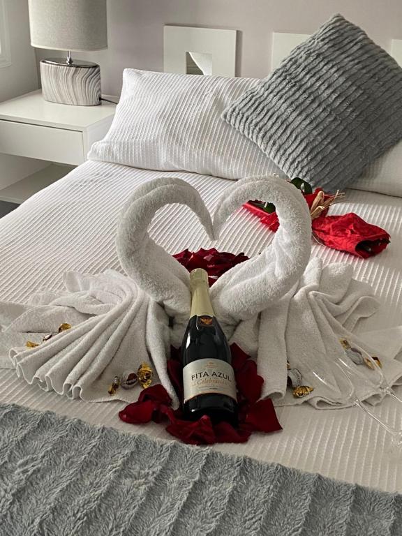two swans making a heart on a bed at Guest House Triunfo in Porto