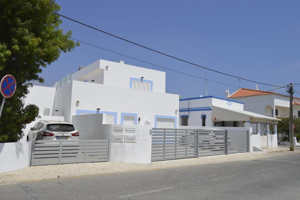 uma casa branca com um carro estacionado em frente dela em Moradia V2 nova e próximo da praia em Vila Nova de Cacela