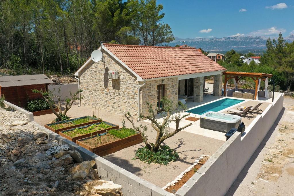 a small house with a swimming pool in front of it at VILLA KARLA in Pridraga