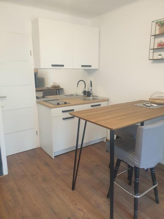 uma cozinha com uma mesa de madeira e um lavatório em MINT APARTMENTS em Zadar