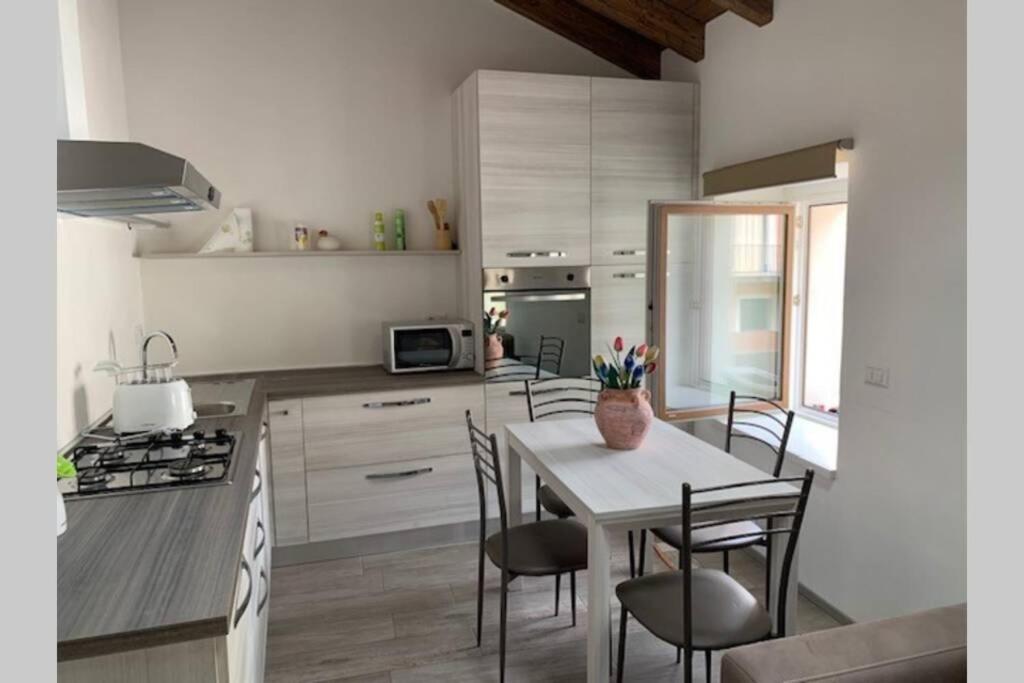 a kitchen with a table and chairs in a kitchen at Casetta al Portico, relax e tranquillità in Porlezza