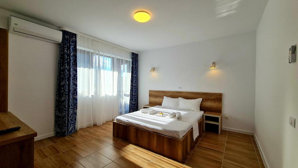 a bedroom with a bed and a large window at Elina2 in Techirghiol