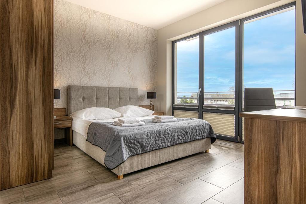 a bedroom with a bed and a large window at Villa Pacyfic in Krynica Morska