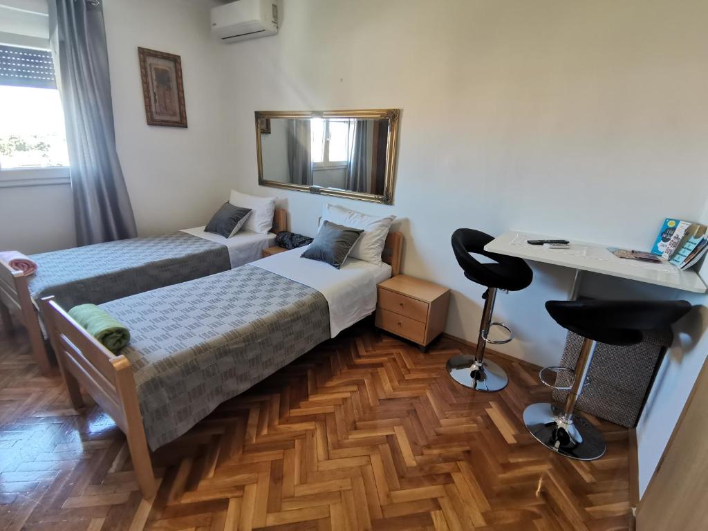 1 dormitorio con 2 camas, escritorio y espejo en studio jasmin, en Rovinj