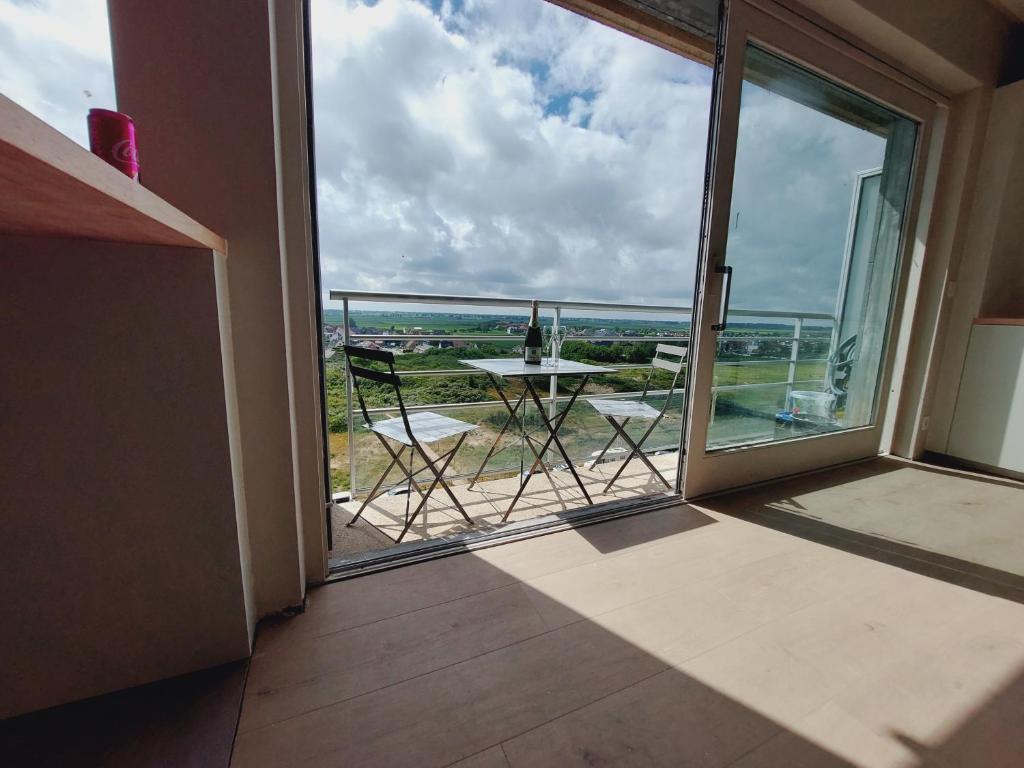 a balcony with a table and a view of the ocean at Studio-M in Middelkerke