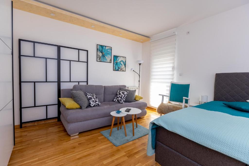 1 dormitorio con sofá, cama y mesa en Apartment SELF CHECK IN 00-24 MM en Belgrado