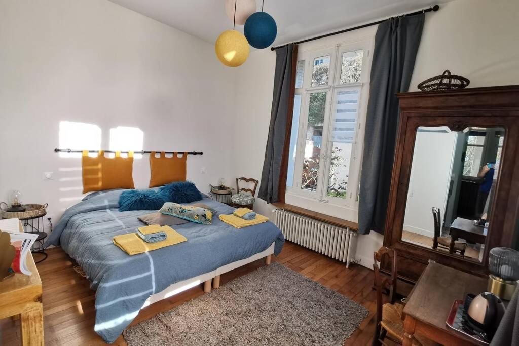 una camera da letto con un letto con un piumone blu di AMALOUYSE Chambre de charme au cœur des châteaux de la Loire a Montlouis-sur-Loire