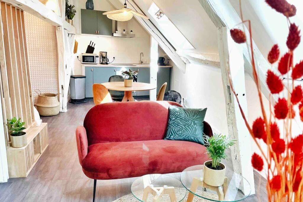 a living room with a red couch and a table at Le Matisse in Bourges