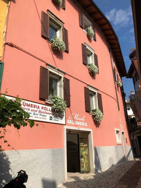 a red building with windows and plants on the front at Bed and Breakfast Casa Mosole in Malcesine