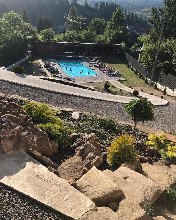 a large swimming pool with rocks in a yard at Sadyba Anastasia in Slavske