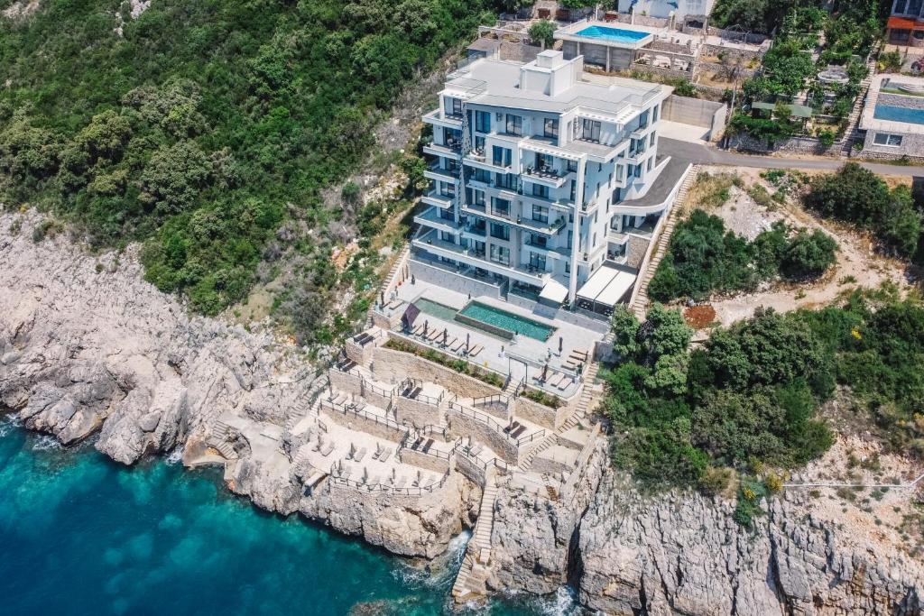a large building on a cliff next to the water at Dollaku Apartments in Bar