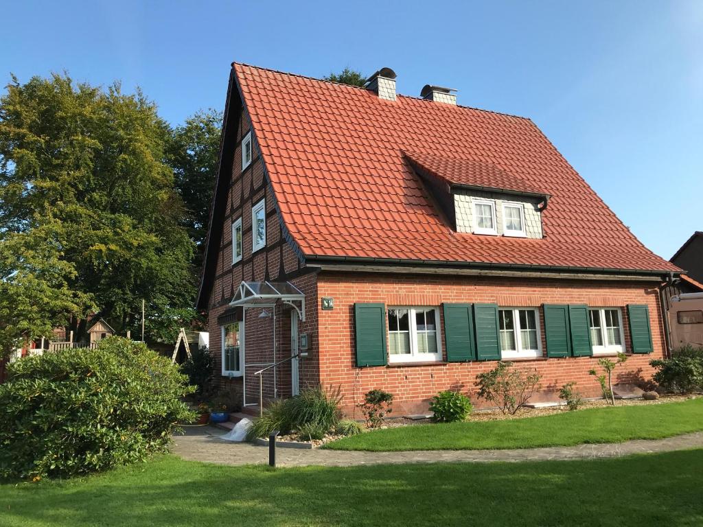 ein Backsteinhaus mit rotem Dach und Hof in der Unterkunft Ferienhaus-Eschede in Eschede