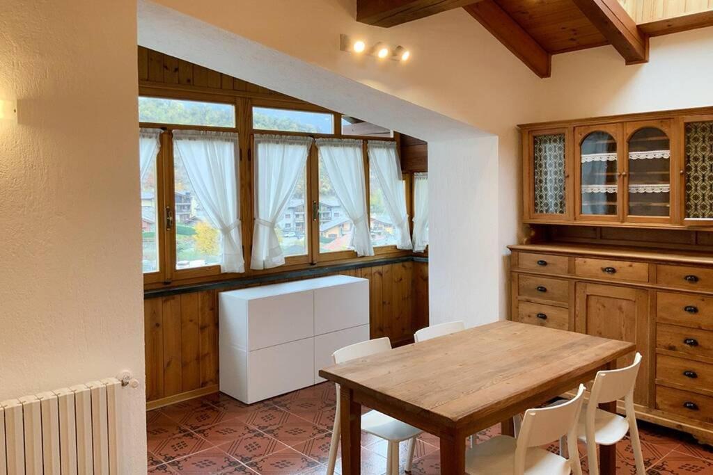 een keuken met een houten tafel en een aantal ramen bij Le Petit Coq in Saint-Pierre