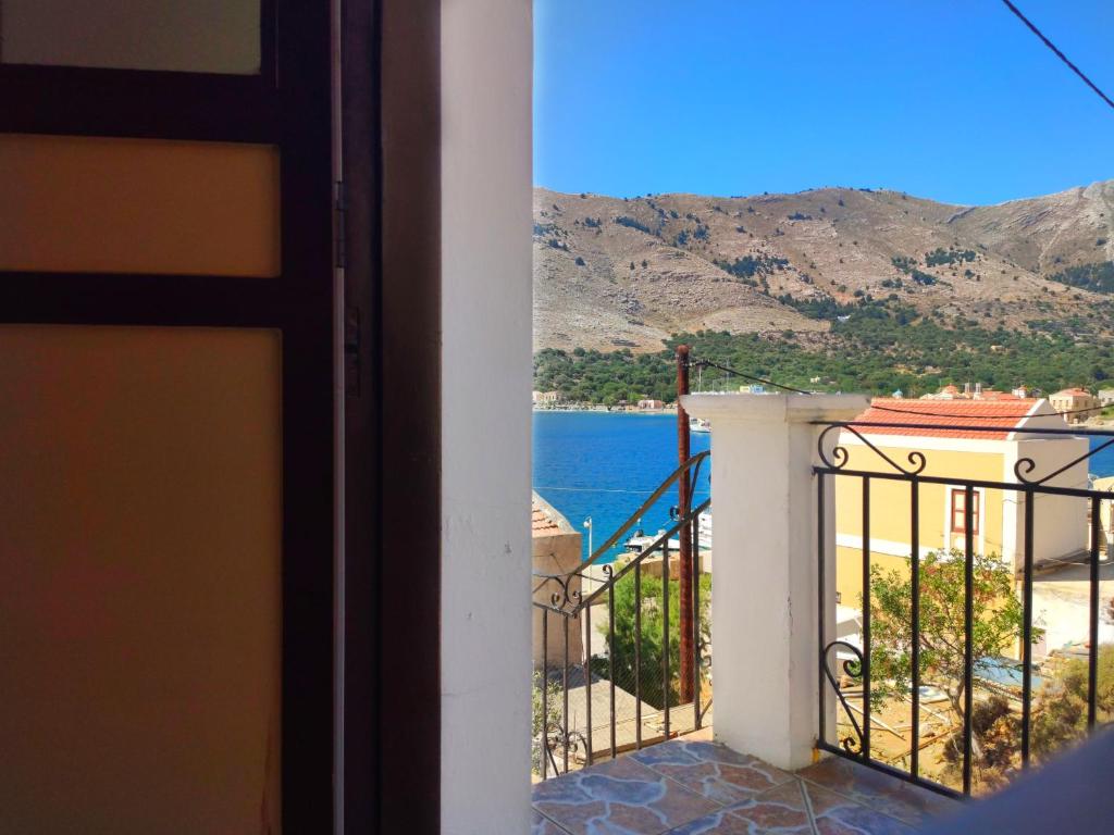 a view of the ocean from the balcony of a house at Gompos Apartment - Cozy Apartment next to the sea - Amazing Sea View in Symi