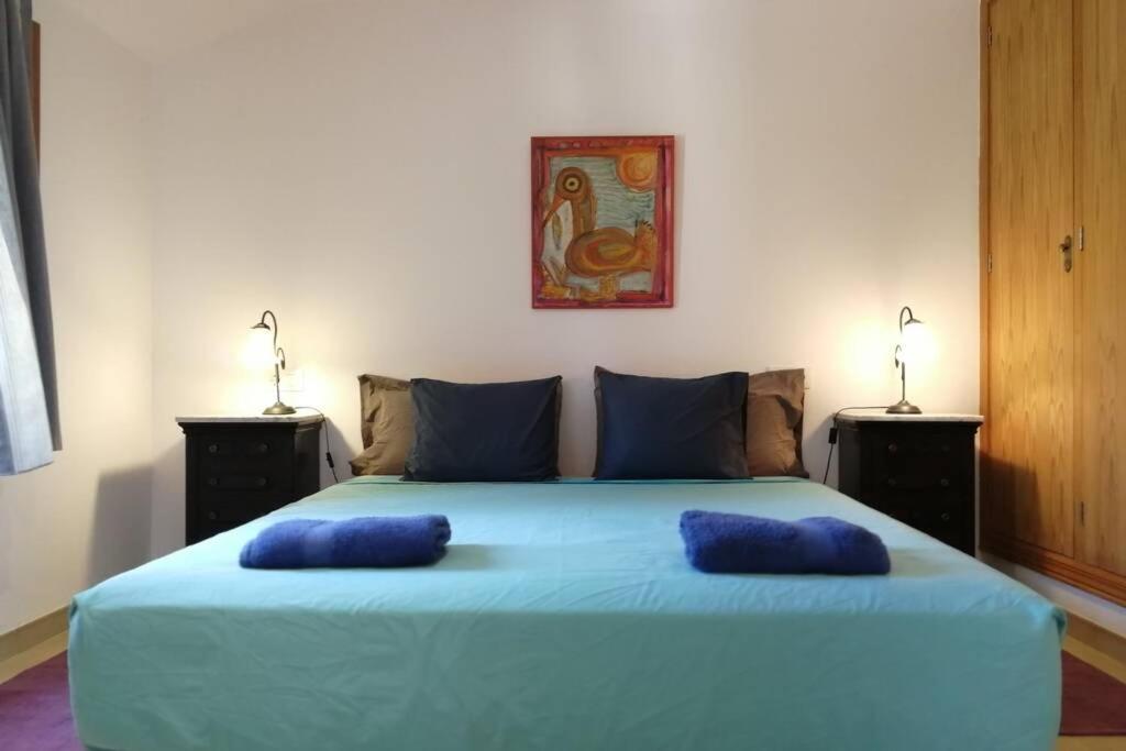 a bedroom with a blue bed with two blue pillows on it at Ses Venes 1 in Maria de la Salut