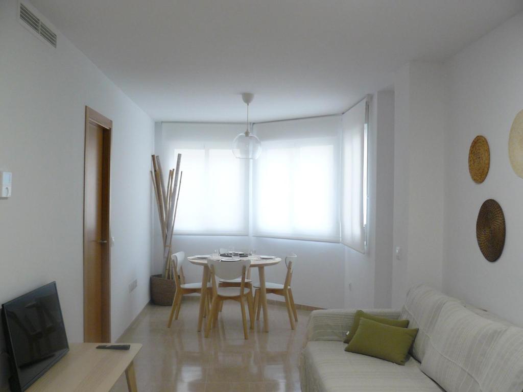 ein Wohnzimmer mit einem weißen Sofa und einem Tisch in der Unterkunft PISO CENTRICO EN BENICARLO 2 in Benicarló