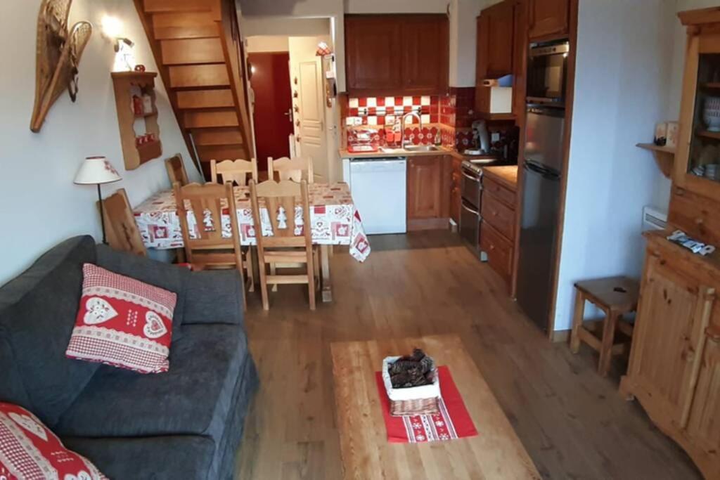 ein Wohnzimmer und eine Küche mit einem Sofa und einem Tisch in der Unterkunft Appartement duplex 7 pers 3 chambres pied des pistes La Joue du Loup in Le Dévoluy
