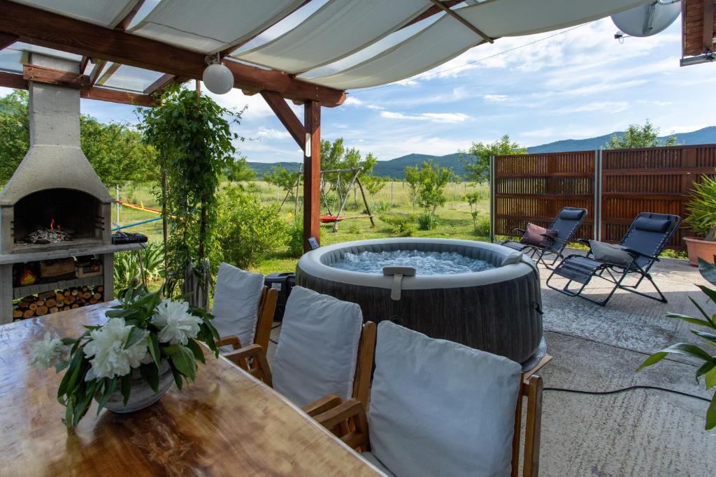 a patio with a hot tub and a table and chairs at Holiday Home Sinac in Sinac