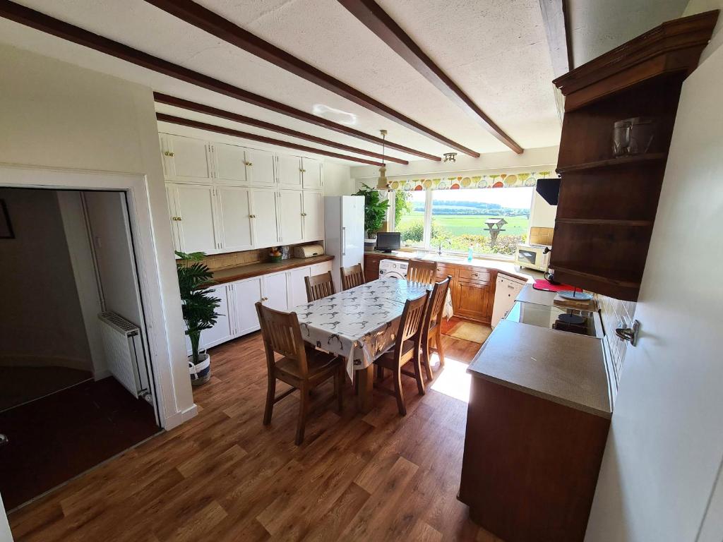 a kitchen with a table and chairs in a kitchen at West Craig Farm House in Forfar