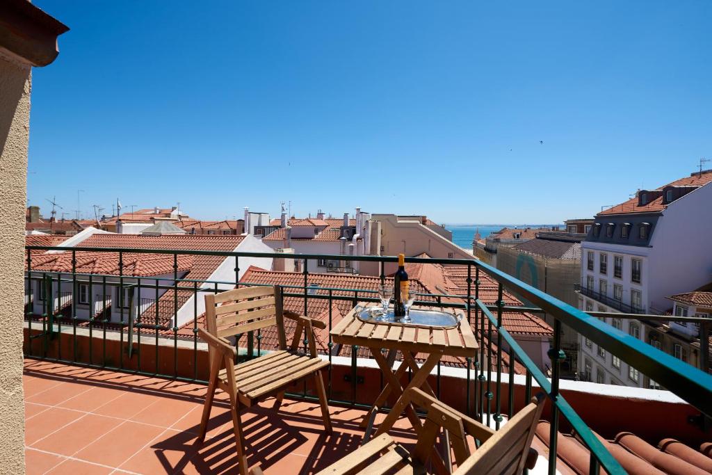 een balkon met een tafel en stoelen op een dak bij 360º Rooftop Lisbon and River View in Lissabon