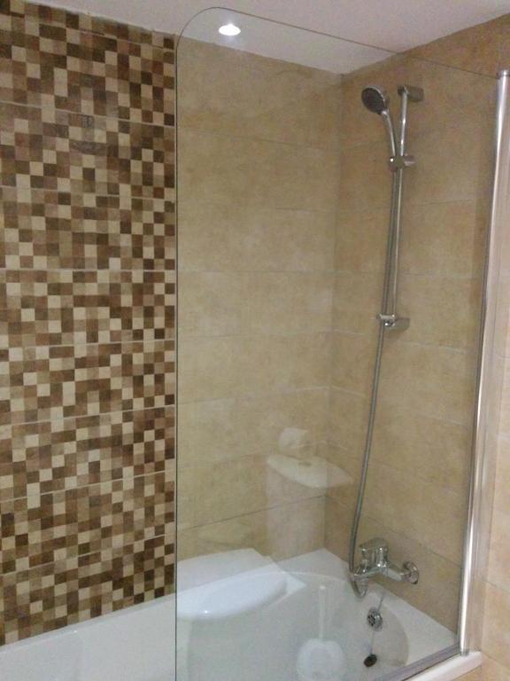 a bathroom with a shower with a toilet and a sink at New Famagusta Hotel & Suites in Ayia Napa