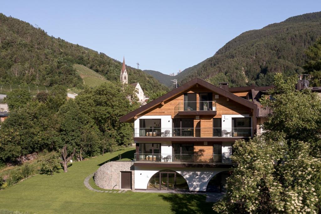 une maison dans les montagnes avec une église dans l'établissement Höllerhof Brixen, à Albes